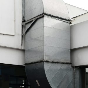 Close-up of a contemporary ventilation duct exterior in a city setting.